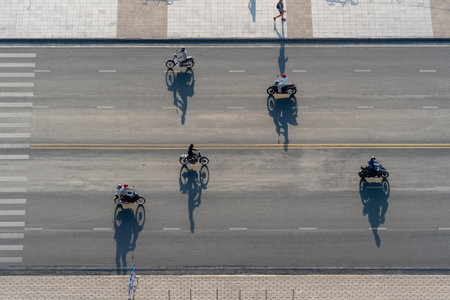 Nha Trang, Vietnam - April 21, 2020: Morning traffic on a beach road near the sea in Nha Trang, Vietnam. A big shadow from passing motorbikes during sunrise, aerial viewのeditorial素材