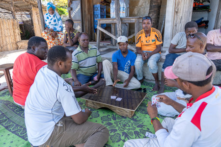 Zanzibar, Tanzania - December 02, 2019: African men playing card games on a street near the tropical beach on the island of Zanzibar, Tanzania, east Africaのeditorial素材