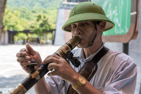 Danang, Vietnam - june 27, 2020: Vietnamese old man smoking a pipe on the street in city Da Nang, Vietnamのeditorial素材
