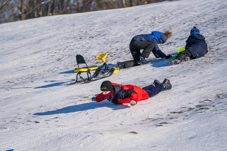 Shepetivka, Ukraine - january 21, 2021: Children sledding with mountain warm winter day. Ukrainian...