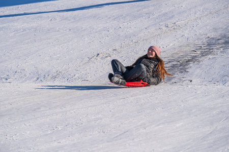Shepetivka, Ukraine - january 21, 2021: Children sledding with mountain warm winter day. Ukrainian...