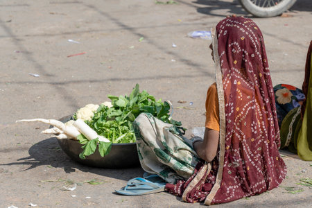 PUSHKAR, INDIA - NOVEMBER 17, 2018: Food trader selling vegetables in the street market in holy city Pushkar, Rajasthan, Indiaのeditorial素材