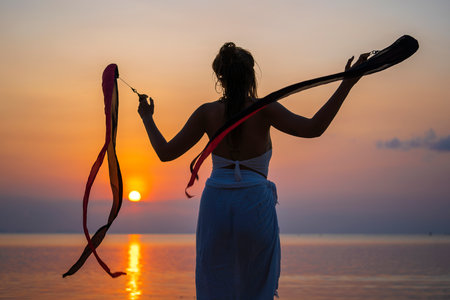 Koh Phangan, Thailand - february 07, 2020: Girl practice a poi for dancing shows on the beach during sunset at tropical island Koh Phangan, Thailandのeditorial素材
