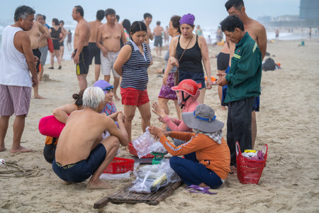 Danang, Vietnam - June 15, 2020: Vietnamese people on the beach buy seafood from local fishermen on the city Danang, Vietnamのeditorial素材