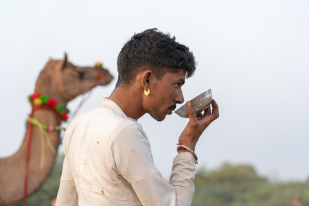 PUSHKAR, INDIA - NOVEMBER 14, 2018: Indian man in the desert Thar during Pushkar Camel Mela near...