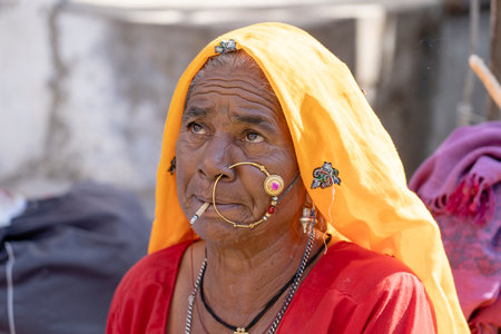 PUSHKAR, INDIA - NOVEMBER 13, 2018: Indian woman in the desert Thar during Pushkar Camel Mela near...