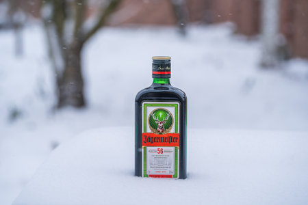Kyiv, Ukraine - january 14, 2021: Bottle of Jagermeister, German digestif made with 56 herbs and spices. Bottle of Jagermeister on a bed of snow and white backgroundのeditorial素材