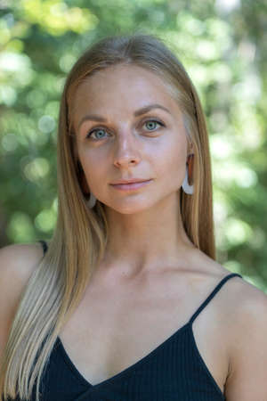 Beautiful caucasian blonde girl in nature background. A portrait of a young woman in tropical...