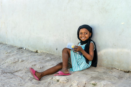 Zanzibar, Tanzania - December 12, 2019: Unknown african young girl on a street of Zanzibar island, Tanzania, East Africa, close upのeditorial素材