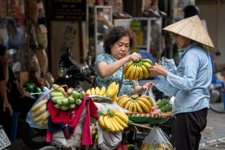 Hanoi, Vietnam - march 01, 2020: Vietnamese woman selling fruits on the street food market of old town in Hanoi, Vietnamのeditorial素材