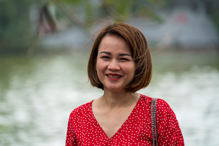 Hanoi, Vietnam - march 01, 2020: Beautiful Vietnamese woman in a red dress on the street in the old town of Hanoi, Vietnamのeditorial素材
