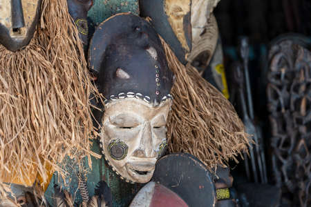 Traditional african wooden masks hanging for sell on the street market on the island of Zanzibar, Tanzania, East Africa, close upの写真素材