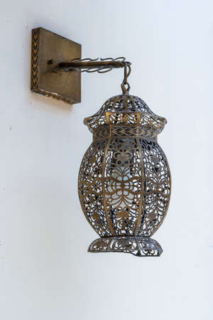 Decorative bronze lamp hangs on a white wall on a street in Stone Town of Zanzibar Island, Tanzania, east Africa, close upの写真素材