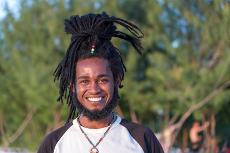 Zanzibar, Tanzania - December 31, 2019: African joyful man with dreadlocks on his head on a tropical beach on the island of Zanzibar, Tanzania, east Africa, close upのeditorial素材