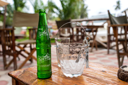 Zanzibar, Tanzania - December 29, 2019: Sprite green glass bottle on the table in tropical cafe. Sprite is a famous colorless, lemon and lime flavored soft drink, created by the Coca-Cola Companyのeditorial素材