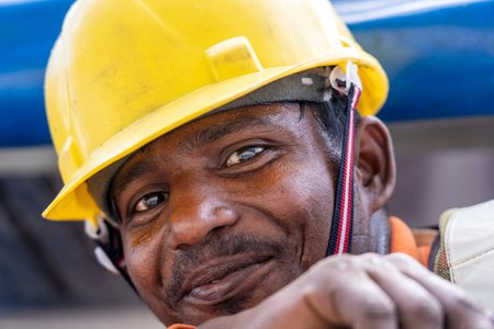 Singapore city, Singapore - February 28, 2020: A migrant worker poses for a photo on a city center construction site in Singapore. The SE Asian city state has a significant migrant worker populationのeditorial素材