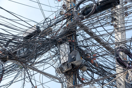 KOH PHANGAN, THAILAND - DECEMBER 22, 2018: Chaos of cables and wires on an electric pole. Many...