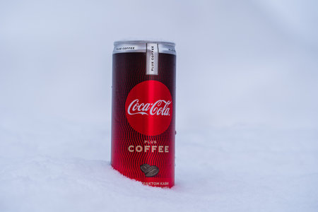 Kyiv, Ukraine - january 15, 2021: Can of Coca-Cola plus coffee on a bed of snow and white background, a new Coca-Cola innovationのeditorial素材