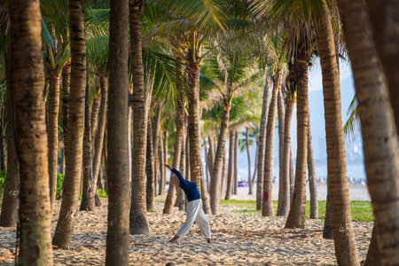 Danang, Vietnam - June 20, 2020: Asian woman working out in the morning before sunrise at beach near sea on the city Da nang, Vietnamのeditorial素材
