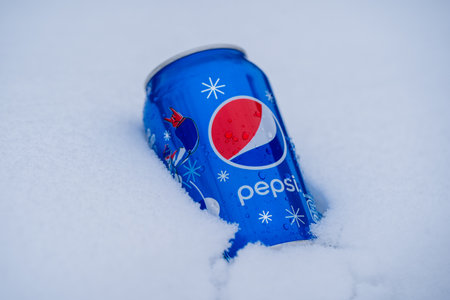 Kyiv, Ukraine - january 14, 2021: Can of Pepsi cola on a bed of snow and white background