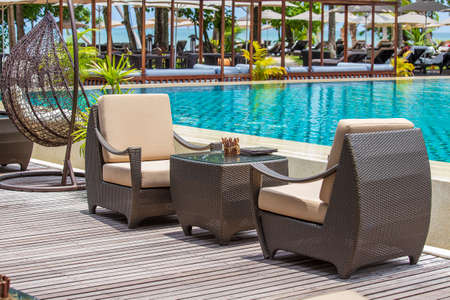 Empty rattan table and chairs on the terrace next to the tropical beach and the sea, Thailand. Close upの写真素材