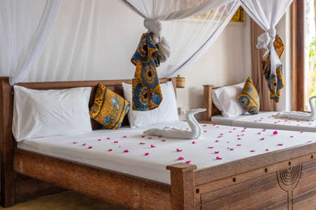 Interior design decor furnishing of luxury show home holiday villa bedroom with four poster bed. Interior design of the tropical villa on the sea on the island of Zanzibar, Tanzania, East Africaの写真素材