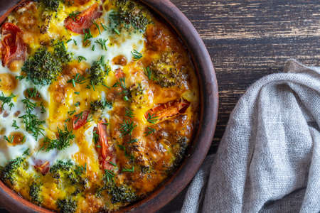 Ceramic bowl with vegetable frittata, simple vegetarian food. Frittata with egg, tomato, pepper,...