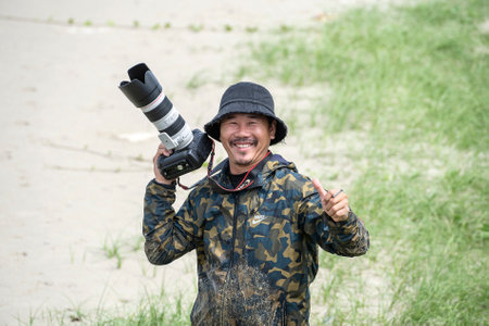 Da Nang, Vietnam - April 27, 2020: Portrait of a happy photographer with a big camera on the seashore near the city of Danang, Vietnamのeditorial素材