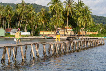 Phu Quoc island, Vietnam - may 05, 2020: Vietnamese woman and her child walk along a narrow wooden bridge in a fishing village on the Phu Quoc island of Vietnamのeditorial素材