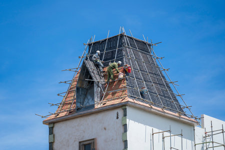 Phu Quoc island, Vietnam - may 25, 2020: Two Vietnamese builders on the roof on the island of Phu Quoc, Vietnamのeditorial素材