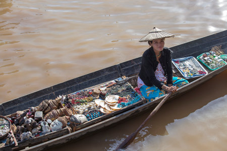 Inle lake, Myanmar, Burma - jan 14, 2016: Unidentified Burmese woman on small long wooden boat selling souvenirs, trinkets and bijouterieat the floating market on Inle Lake, Myanmarのeditorial素材