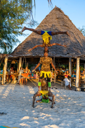 Zanzibar, Tanzania - December 31, 2019: African gymnasts perform in front of tourists on a tropical beach before the New Year on the island of Zanzibar, Tanzania, east Africa, close upのeditorial素材