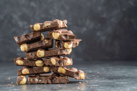 Pile chocolate with nuts on the gray background, close upの写真素材