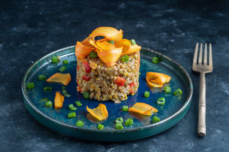 Boiled buckwheat with fried eggs, red peppers, carrots and onions, close up, Ukraine. Food background. Healthy foodの写真素材