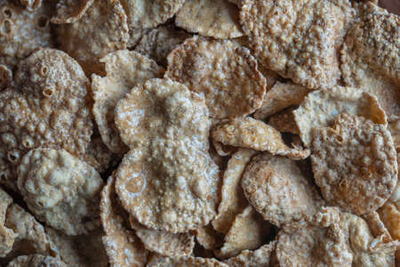 Whole grain glazed flakes in plate, close up, top view. Healthy breakfast, whole grain muesli in a...