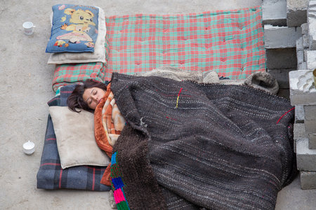 Lamayuru, Ladakh, India - June 14, 2015: Indian girl sleeping on the street near monastery Lamayuru, India. During the festival in Tibetan monastery of Lamayuru accommodation for all is not enoughのeditorial素材
