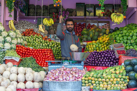 Leh, India - June 21, 2015: Indian man sells vegetables and fruits at the local street market in mountain village Leh, Ladakh region, north India, close upのeditorial素材