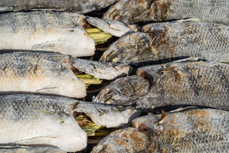 Thai street vendor sells grilled sea fish at street food market in island Koh Phangan, Thailand. Close upの写真素材