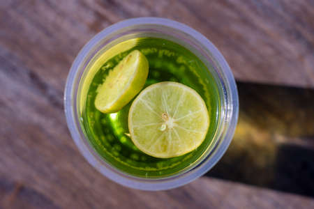 Mojito drink in a plastic cup on wooden table background, top view, Egyptの写真素材