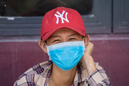 Phu Quoc island, Vietnam - may 25, 2020: Happy Vietnamese girl with protective mask on the face on a...
