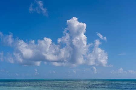 White beautiful clouds and blue sky over sea water waves on the island of Zanzibar, Tanzania, East Africa. Travel and nature conceptの写真素材
