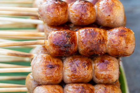 Grilled Thai sausage at street food market in Thailand, close up. Traditional Thai sausage with pork and rice, delicious street foodの写真素材