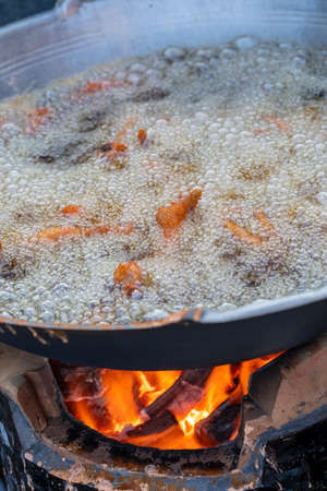 Boiling oil in frying pan for cooking. Thai street vendor sells grilled chicken legs meat at street...