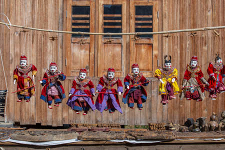 Colorful puppets in a tourist stall on the street market in Burma. Souvenir items for sale in Myanmar. Handmade dolls hanging on display storeの写真素材