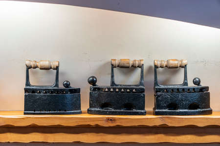 Old vintage flat iron with wooden handle, close up. Three antique, retro iron, Transnistria, Moldovaの写真素材