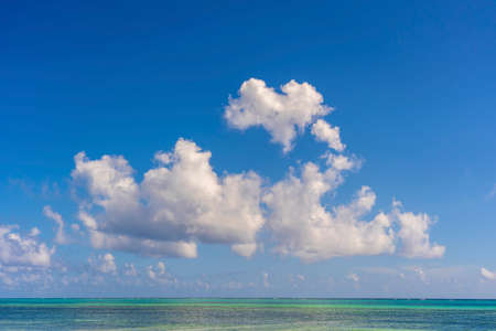 White beautiful clouds and blue sky over sea water waves on the island of Zanzibar, Tanzania, East Africa. Travel and nature conceptの写真素材