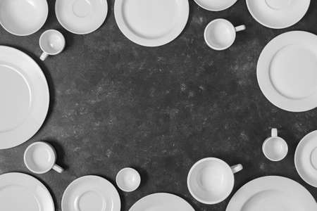 Many white empty ceramic plate and cup on black background with copy space for your text. Top view, close upの写真素材