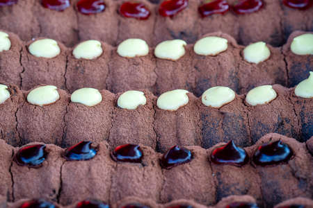 Chocolate donuts at street food market in Thailand, close up. Tasty chocolate donuts with jam and...