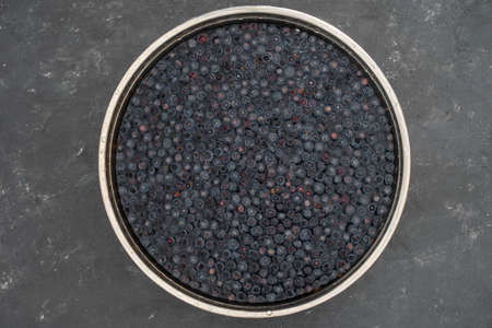 Forest wild blueberry in water in an iron bowl, close up. Summer forest berry