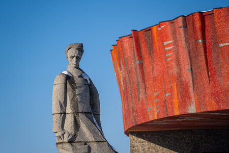 Monument to soviet realist writer Nikolai Ostrovsky in Shepetivka, Ukraine. Statue of Nikolai Ostrovsky against the blue skyのeditorial素材
